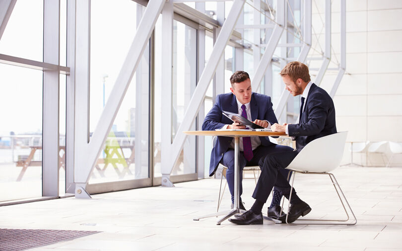 stock-photo-73550601-two-business-colleagues-at-meeting-in-modern-office-interior