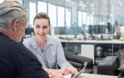 stock-photo-83449089-mid-adult-busineswoman-using-tablet-with-mature-man-smiling