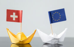 Papierschiffchen mit EU und Schweiz Flagge in Bewegung