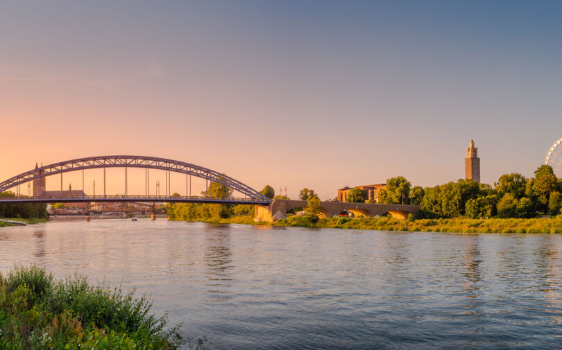 Panoramablick über bunten Sonnenuntergang vor Dom, neue Sternenbrücke, alte Brücke und Stadtbeobachtung Riesenrad in Magdeburg
